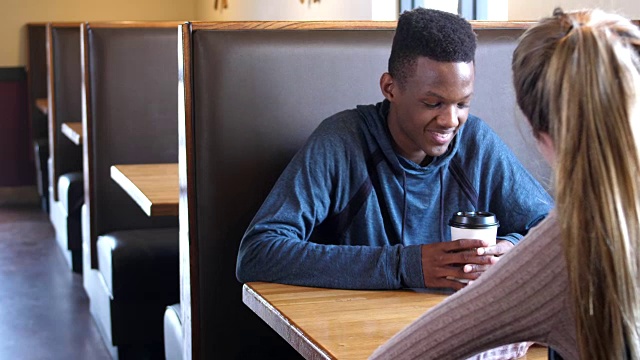 跨种族的青少年情侣在餐厅聊天视频素材