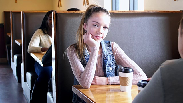 十几岁的女孩和男朋友坐在咖啡店里视频下载