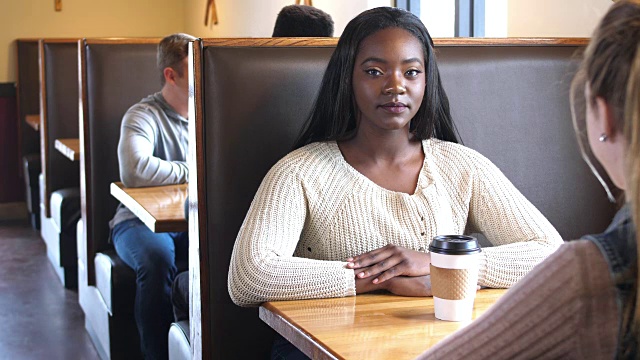 一个非洲裔少女和一个朋友在咖啡店视频素材