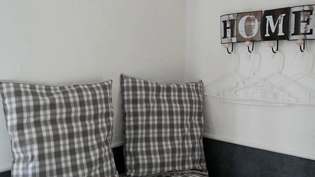舒适的角落，格子枕头和一个可爱的时尚衣架在墙上写着一个舒适的家的名字视频下载