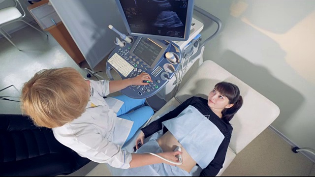 俯视图的孕妇通过超声会议与女性妇科医生视频下载