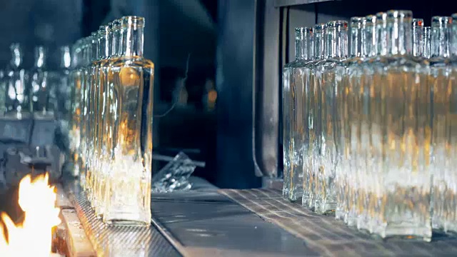 直排水晶干净的玻璃瓶沿着传送带通过火和搬迁从它视频素材
