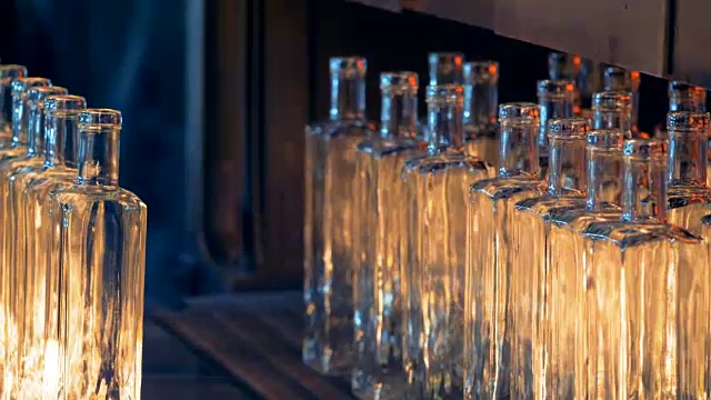 由玻璃制成的瓶子反射火焰光，并由压机移动视频素材