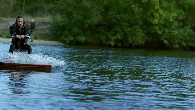 在平静的水面上滑行。男性骑手极限生活视频素材