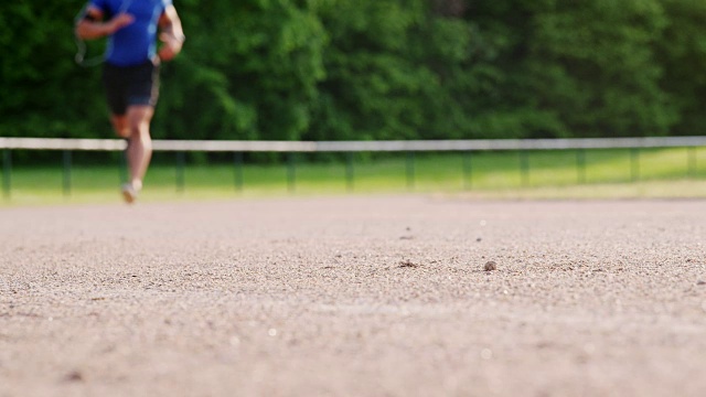 男运动员在跑道上跑过焦平面视频素材