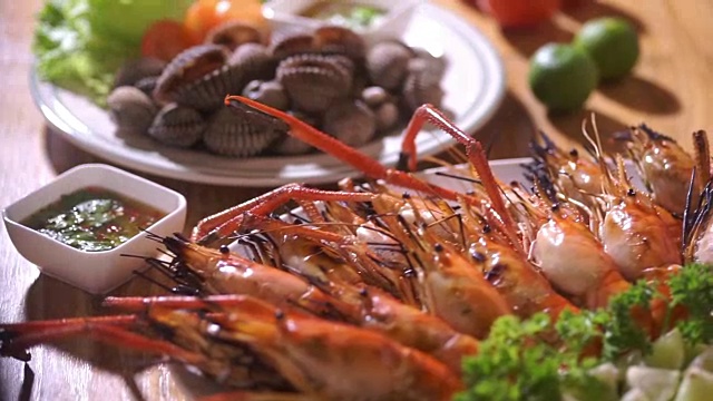 新鲜海鲜配烤虾和贝类。视频素材