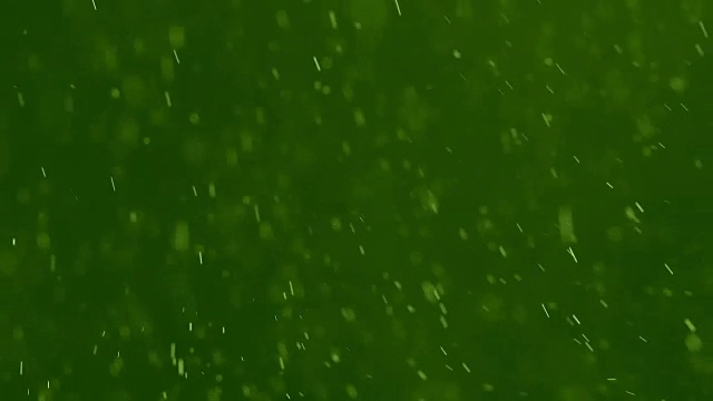 白色颗粒在绿色背景下旋转视频素材