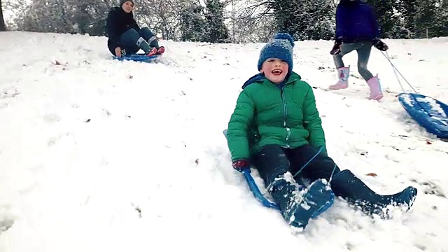 一家人在冬天滑下完美的山坡视频素材
