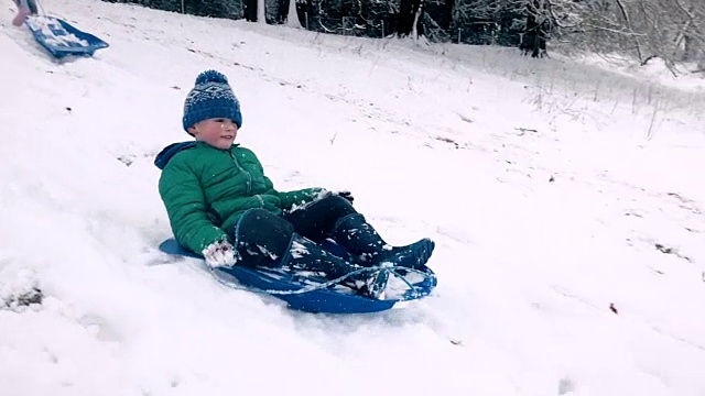小男孩在白雪覆盖的山坡上滑雪视频素材