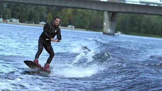 一名男子在城市桥下的波浪上滑行视频素材