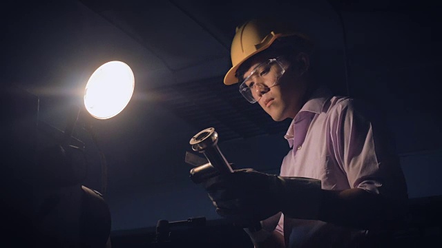 年轻的工厂工程师在工厂的一个工业机器后面操作检查质量视频下载