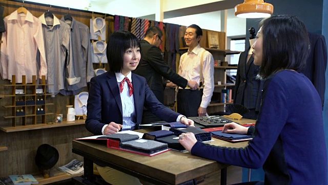 一位高级西服店里的女裁缝正在和一位顾客交谈视频素材