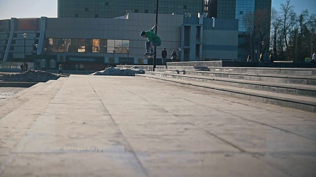 滑板者在城市街道上跳下楼梯视频素材