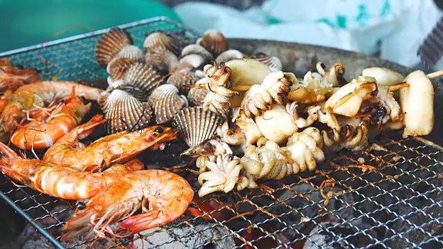 4k:新鲜海鲜配烤虾、鱿鱼和贝类。视频素材