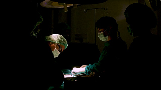 在手术室里给病人做手术的外科医生。视频下载