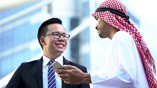 阿拉伯和中国商人在商务会议上讨论。现代城市的背景。国际业务与海外合作。视频下载