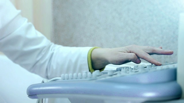 键盘超声设备。近处，医生的手按下按钮，扫描男病人视频下载