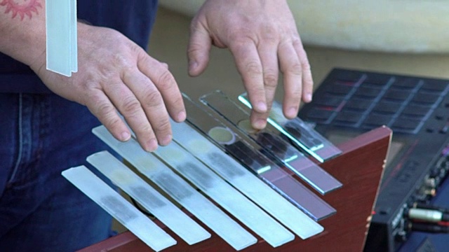 特写:陶艺工坊里，音乐家的手在弹奏玻璃乐器视频下载
