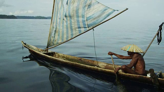 印度尼西亚，一名男子用桨划着一艘旧帆船视频下载