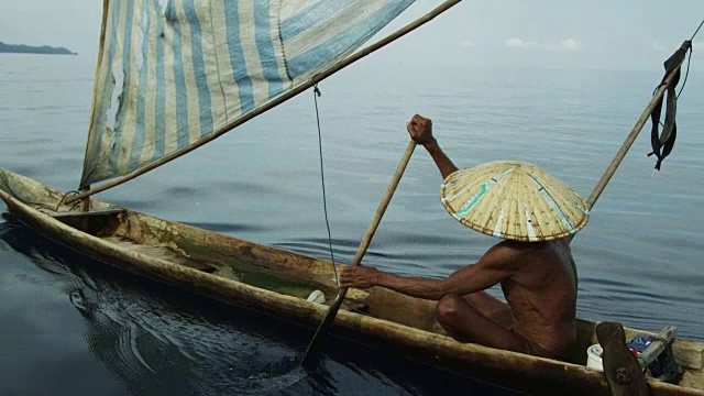 一名印尼男子在海湾划着船视频下载