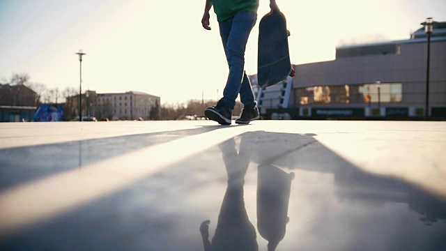 在阳光明媚的日子里，滑板手在街上玩滑板视频素材