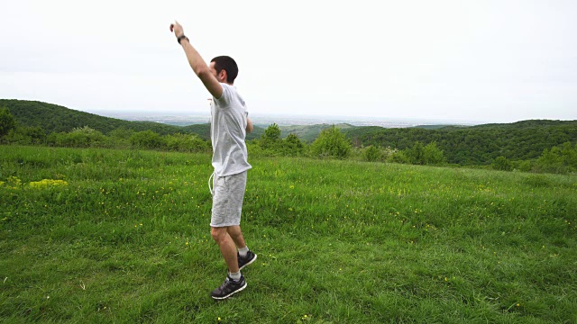 快乐的运动员带着秒表在大自然中奔跑，庆祝他计时成功。视频素材