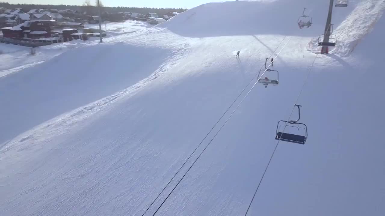滑雪胜地雪山上滑雪的男子鸟瞰图。滑雪度假和在豪华度假村的滑雪斜坡上的冬季运动无人机的观点。冬天在雪山上滑雪视频素材