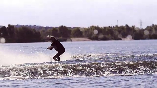 在慢动作的尾流滑板上做极限跳跃的人。极端的水上运动视频素材