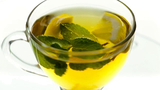 热凉茶，加入姜，柠檬和薄荷。透明茶壶中的姜汁饮料。健康的柠檬茶。视频下载