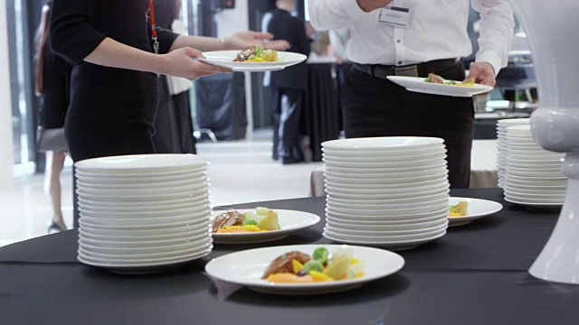 会议与会者从餐桌上拿走与主菜一起的盘子视频下载