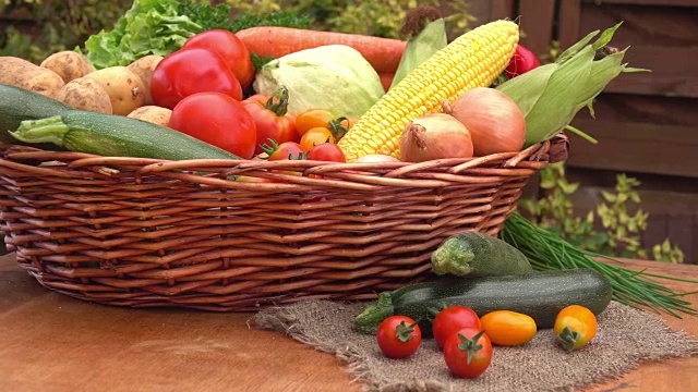 篮子里装着玉米，西红柿，土豆和洋葱的静物画视频素材
