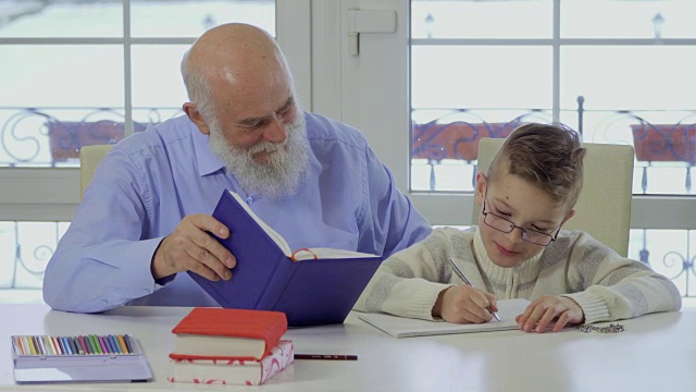 爷爷和孙子一起做家庭作业视频素材