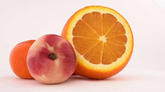 油桃、橘子和柑橘在转盘上旋转。孤立在白色的。特写镜头。视频下载