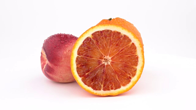 多汁的橘子水果，桔子和油桃与水珠旋转在白色的背景。孤立。关闭了。视频下载