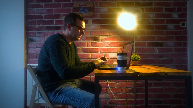 坐在家里用笔记本电脑工作的男人。在家办公的男性。视频素材