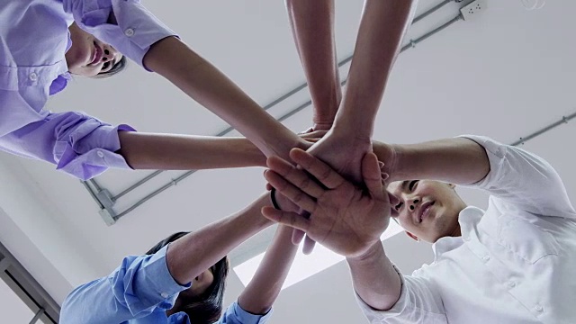 年轻的商人们把手放在一起。堆栈的手中。团结协作的理念。视频下载