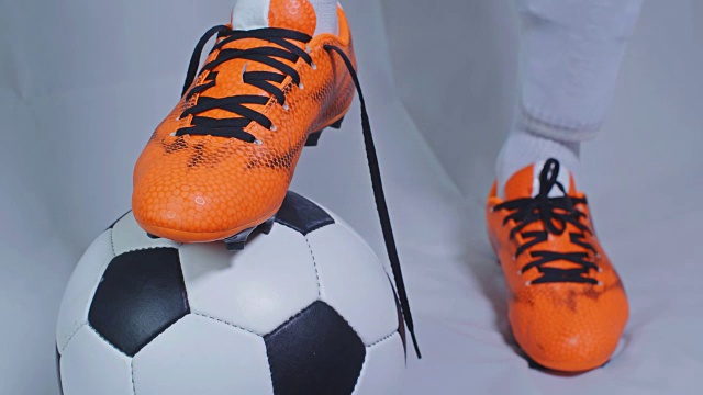 足球,足球比赛。职业足球运动员扣上红色的鞋，白色的底色视频下载