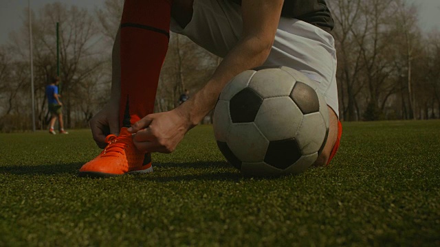 足球运动员在足球场上系鞋带视频素材