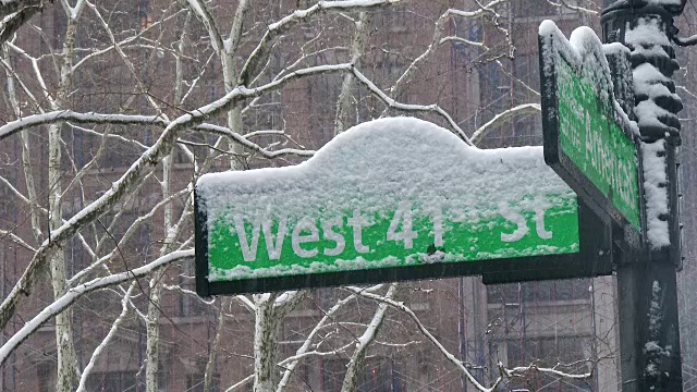 雪花飘落在纽约市街道指示牌上。41街和6街。视频下载