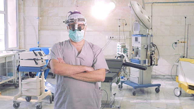 专业医生的肖像。一名头戴特殊检查仪器的男医生正站在手术室里视频素材