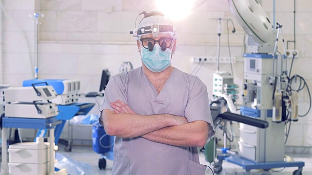 一名男性专业外科医生在镜头前走着走着停着，同时直视着镜头视频素材