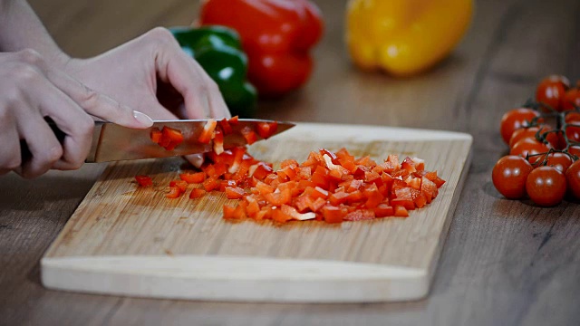 切鲜红辣椒。木板上放胡椒。烹饪用刀切蔬菜。视频下载