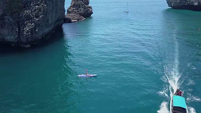 航拍:一名年轻女子划着皮划艇疾驰而过视频下载