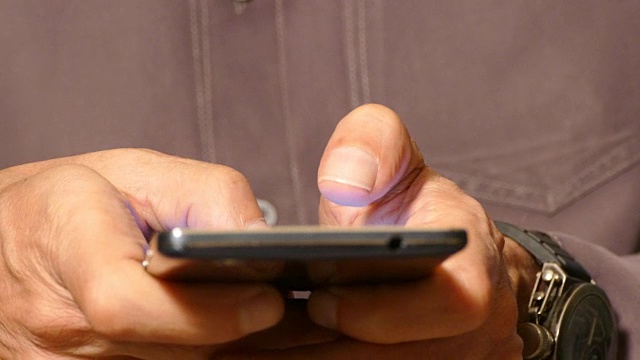 一个男人在触屏智能手机上打字视频素材