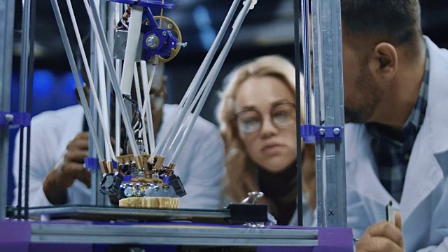 研究人员观察3d打印机器的运行过程视频素材