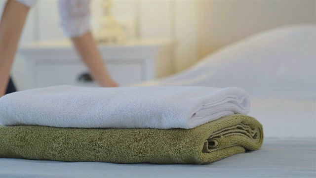 酒店服务员在整理床铺，前面放着干净的毛巾视频下载