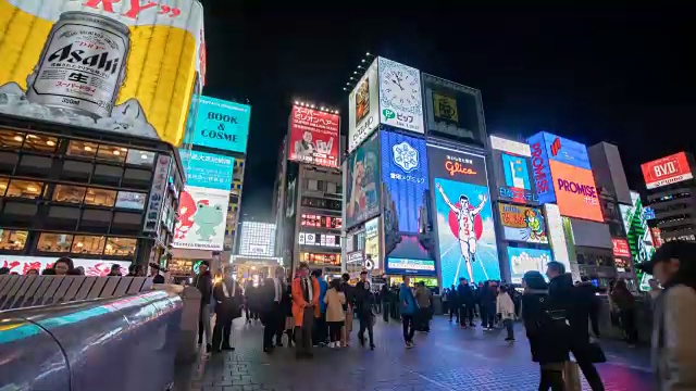 4k时光流逝:人们走在日本大阪道顿堀的夜间购物街上，倾斜拍摄视频素材