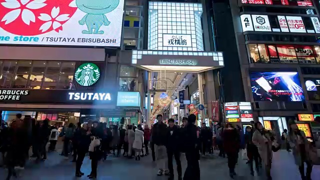 4k时光流逝:人们走在日本大阪道顿堀的夜间购物街上，放大拍摄视频素材