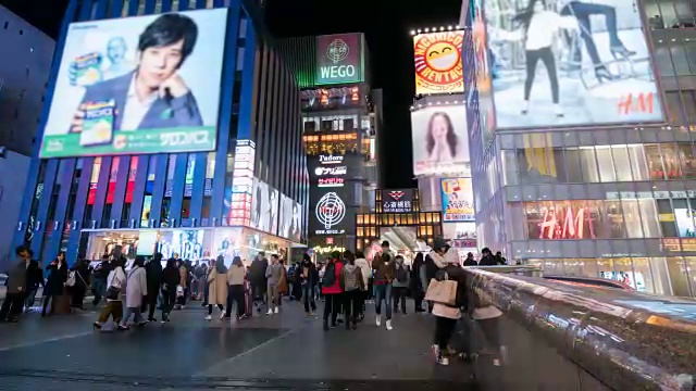 4k时光流逝:人们走在日本大阪道顿堀的夜间购物街上，右拍视频素材