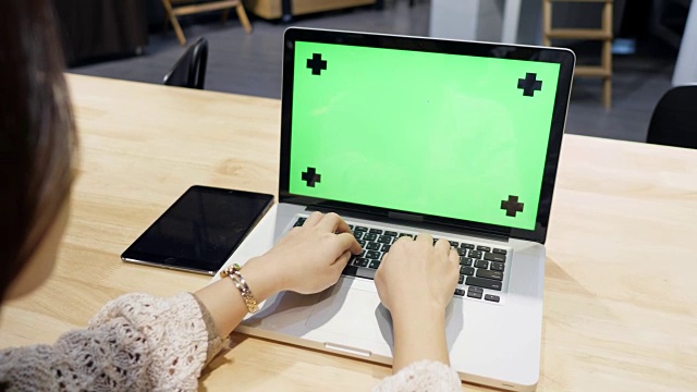 年轻女子用绿色屏幕输入笔记本电脑视频素材